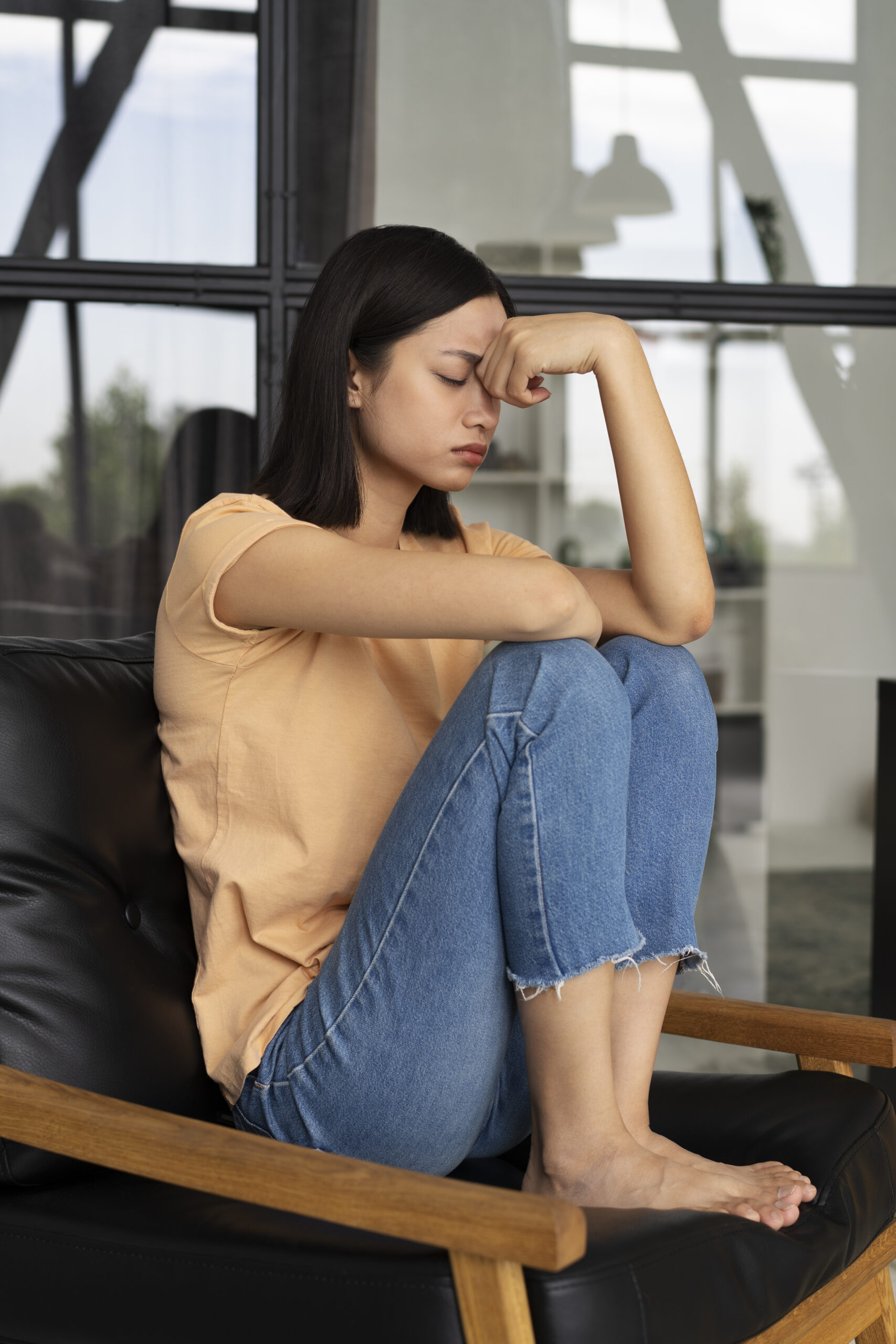 Woman sitting on chair looking stressed
